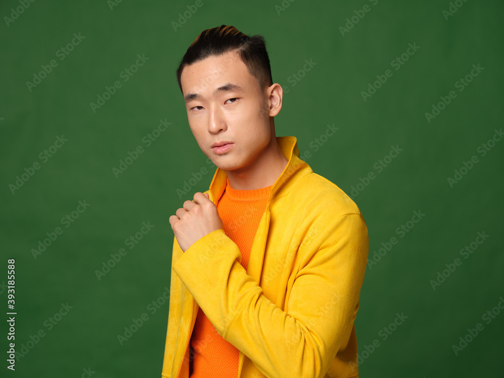 Asian man in yellow jacket orange t-shirt model cropped view