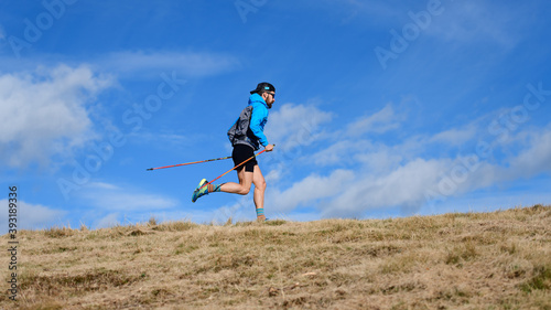 A sporty man with climbing poles during endurance trail