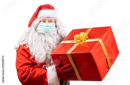 Santa Claus with face mask holding a christmas gift, isolated on white background.