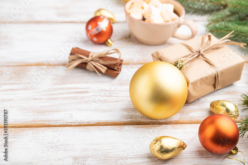 Christmas or New Year composition. Decorations, box, balls, fir and spruce branches, cup of coffee, on a white wooden background. Side view, copy space.