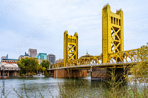 Tower Bridge and city skyline in Sacramento, California, USA beyound tree branches during the autumn season