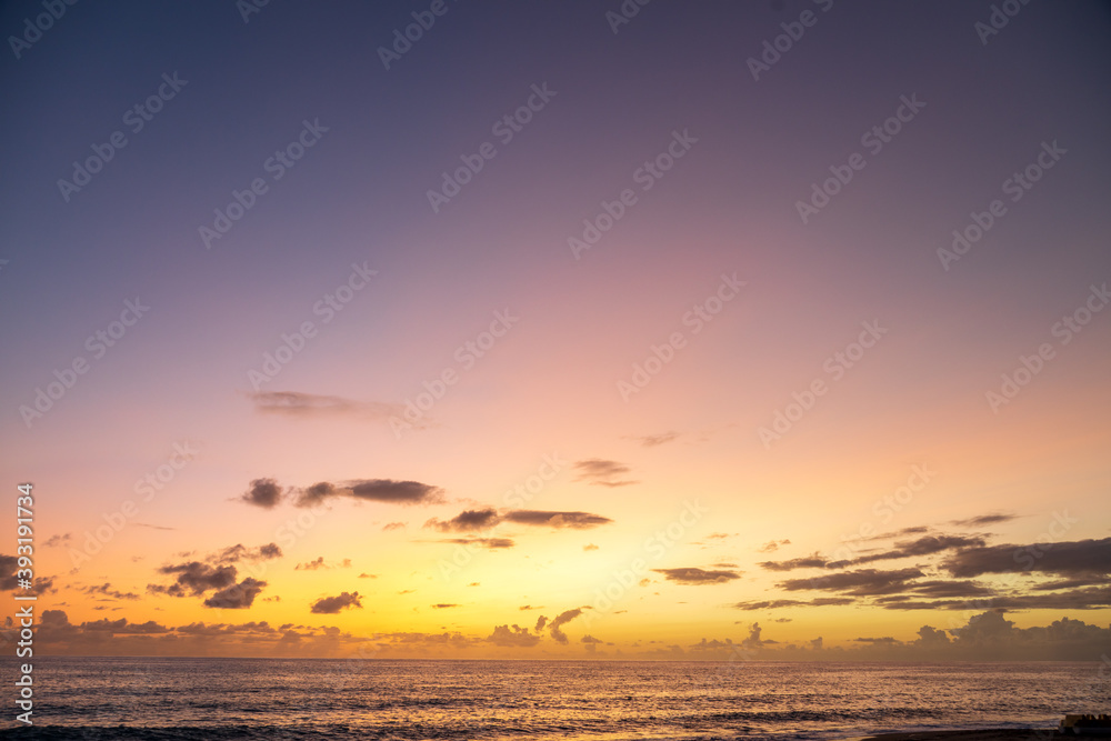 Dramatic sea shore sunset with sun setting down at the cloudy skyline with orange and vivid blues. Dramatic sea shore sunset with sun setting down at the cloudy skyline with orange and vivid blues.