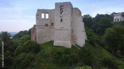 Zoom shot of historical building situated on green hill. Drone aerial view.