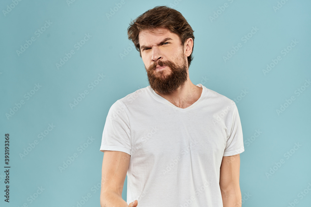 Obraz premium Man gestures with his hands emotions displeasure white t-shirt blue background
