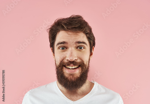Portrait of a man in a white T-shirt on a pink background close-up model