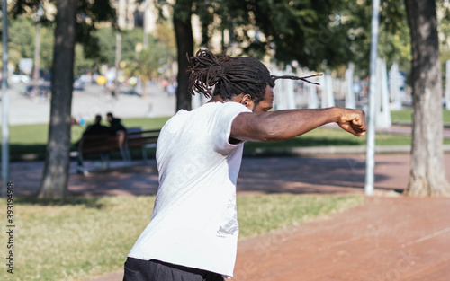 Afro man with dreadlocks training martial arts in a city park