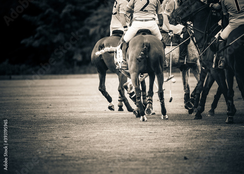 Players riding polo ponies in a polo match at Kirtlington Park, Oxfordshire.