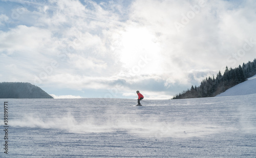 Fast going skier boy ride down the mountain hill. Active winter sport concept image.