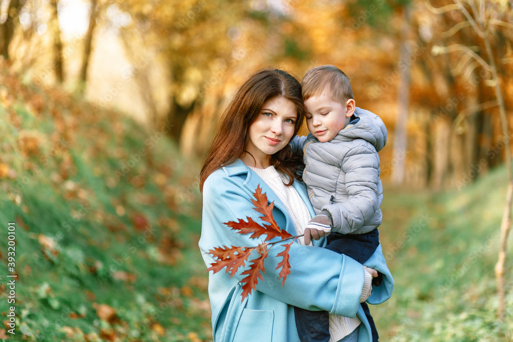 Mother hugs toddler boy ion golden autumn background Mother hugs toddler boy ion golden autumn background