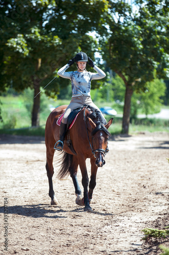 Young pretty girl at horse riding training process