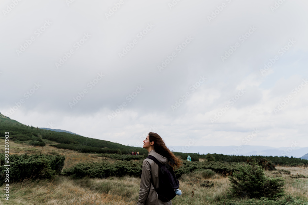 Girl is travelling in the mountains. Foggy day. Hiking and climbing up to the peak of the mountain. Beautiful nature of Ukraine.