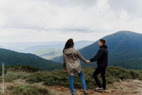 Couple at the peak of the mountain. Lifestyle of travelling people. Love story in the mountains