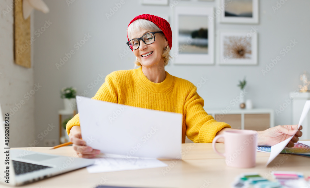 Happy senior freelancer reading papers. Happy senior freelancer reading papers.
