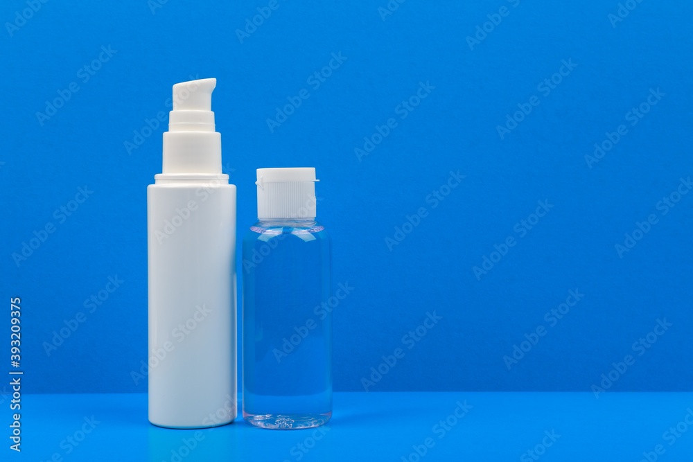 Still life with unbranded face cream and skin lotion on a blue background with a space for text. Concept of daily skin care Still life with unbranded face cream and skin lotion on a blue background with a space for text. Concept of daily skin care
