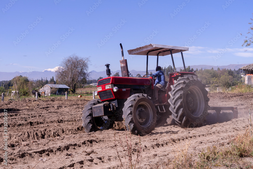 Tractor in a field with a mountain view Tractor in a field with a mountain view