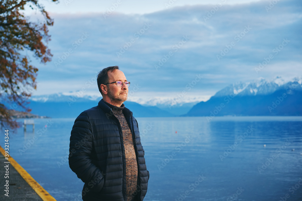 Middle age man enjoying promenade next to lake Geneva, Lausanne, Switzerland