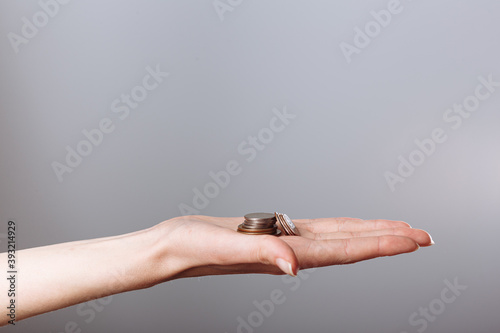 woman's hand holding coins isolated on gray background. Concept crisis, save money © lightscience