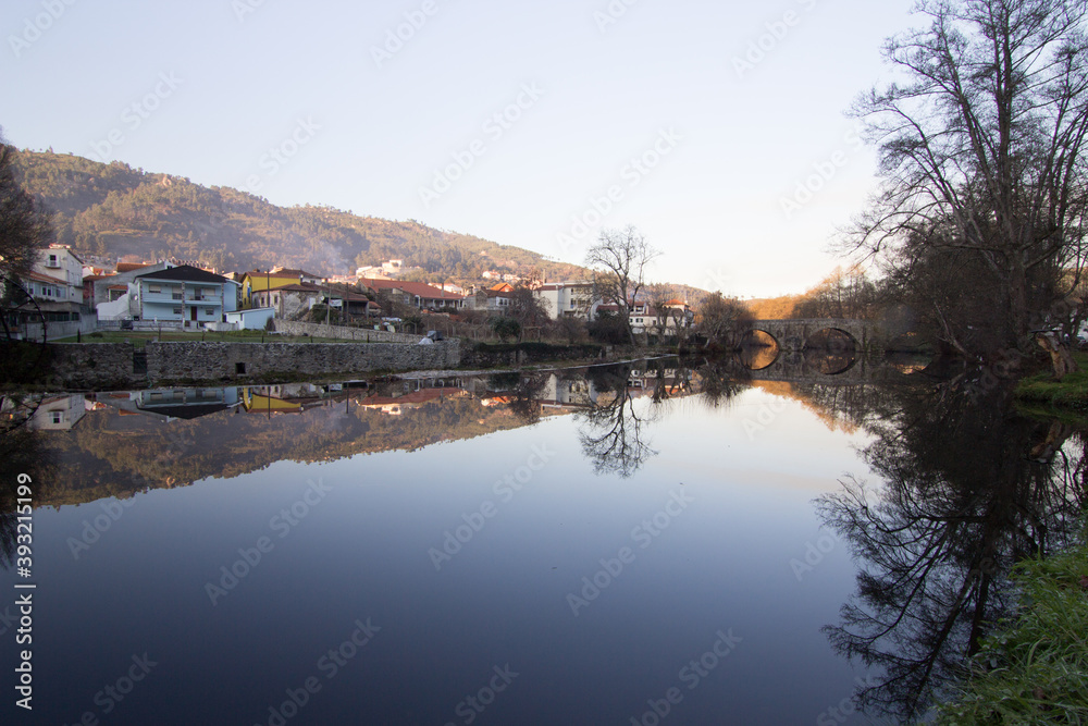 Mirrored village on the river