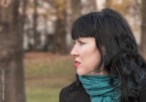 close-up portrait in profile of a forty-five year old woman with a sad look