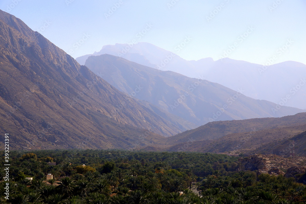 Fototapeta premium Perspective view of the mountain range, above the palm grove, Nakhal, Al Batinah Region of Oman