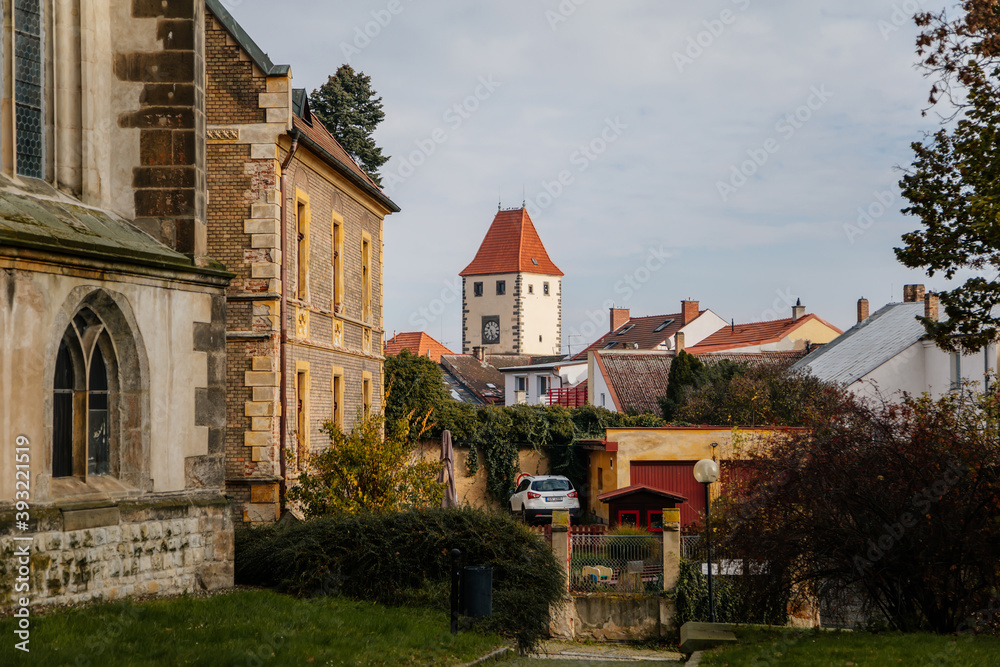 Picturesque landscape with Prague Gate tower and medieval gothic catholic church of Saints Peter and Paul near castle Melnik in sunny autumn day, Central Bohemia, Czech republic