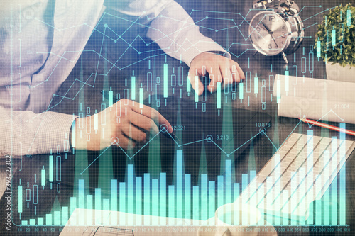 Double exposure of man's hands holding and using a phone and financial graph drawing. Analysis concept. © peshkova