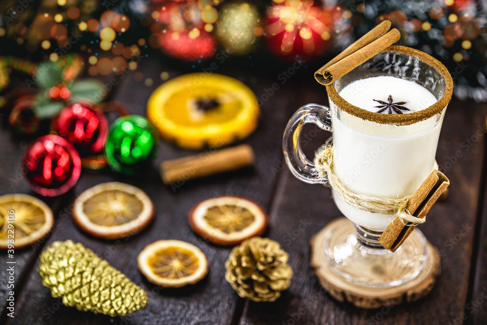 warm homemade Christmas eggnog, based on eggs and alcohol, with dried citrus fruits in the background. Eggnog known as: Auld Man milk, milk and pisco, momo cola, coquito, Crème de Vie or Eierlikör