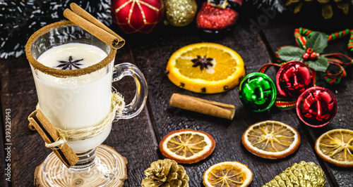 warm homemade Christmas eggnog, based on eggs and alcohol, with dried citrus fruits in the background. Eggnog known as: Auld Man milk, milk and pisco, momo cola, coquito, Crème de Vie or Eierlikör photo