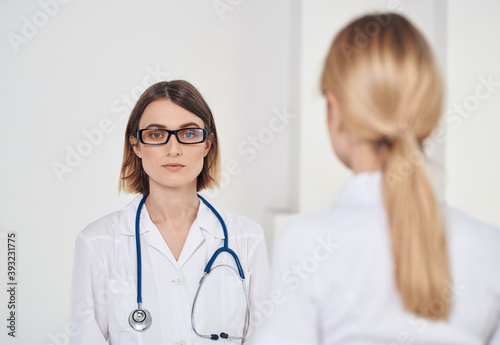 professional doctor with a stethoscope explaining something to a patient in a t-shirt