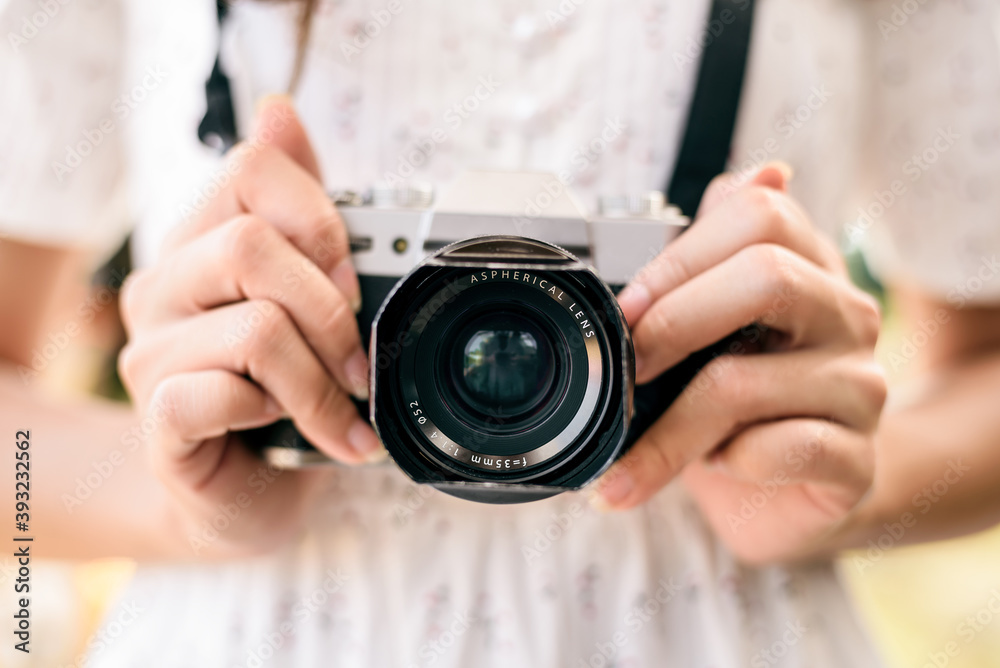 young woman taking photos with retro style camera ,  vintage concept