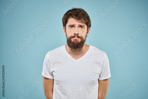 Man in white t-shirt lifestyle studio emotions facial expression blue isolated background 