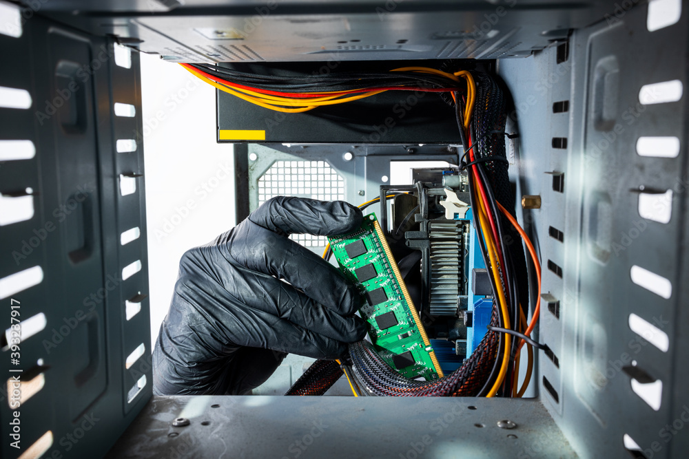 male person or technician worker installing ddr ram memory module to a desktop pc case. close up. looking inside computer case. appliance service concept male person or technician worker installing ddr ram memory module to a desktop pc case. close up. looking inside computer case. appliance service concept
