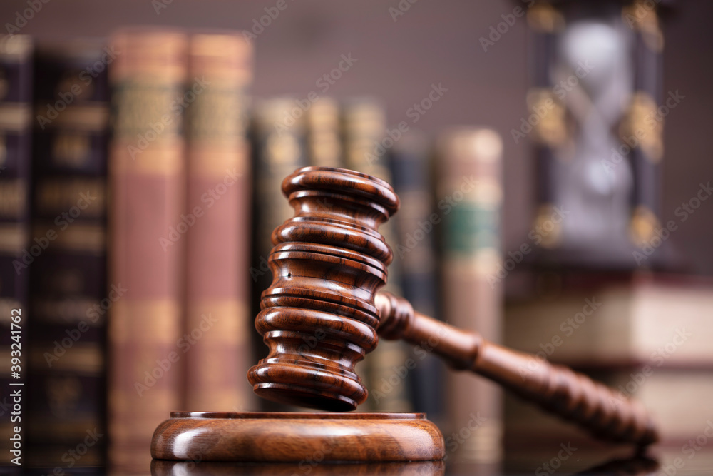 Law theme. Judge chamber. Judge’s gavel and collection of legal books on the brown desk and the brown background. Law theme. Judge chamber. Judge’s gavel and collection of legal books on the brown desk and the brown background.