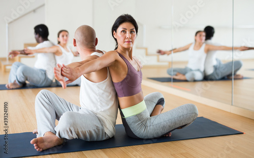 Portrait of young adult woman practicing partner yoga at studio