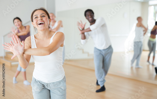 Adult people learning swing steps at dance class and smiling