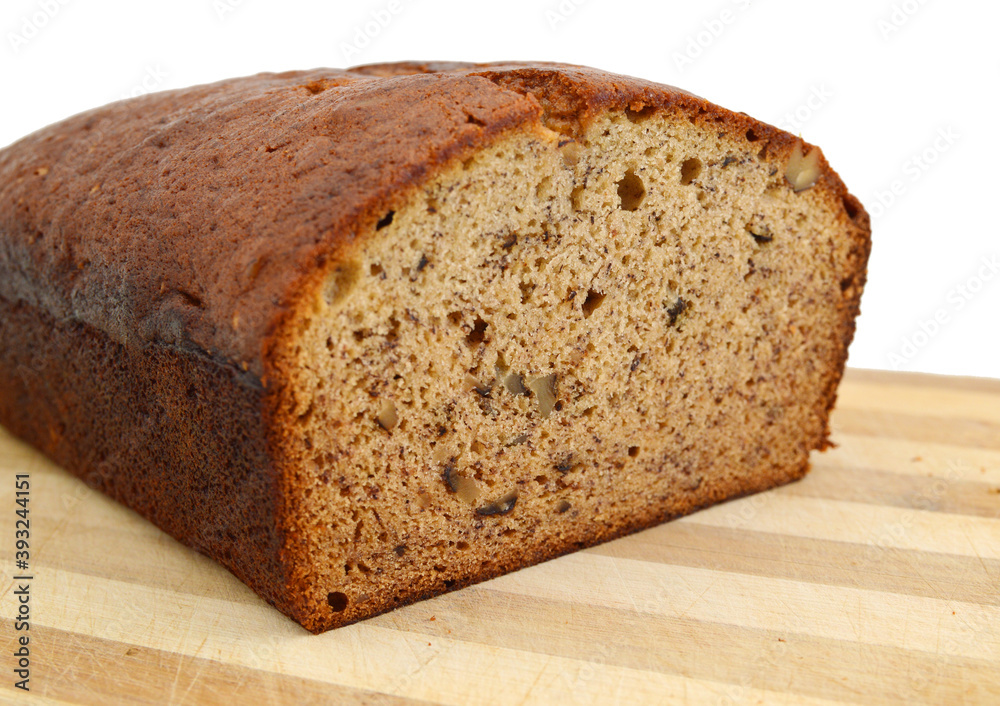 A fresh homemade loaf of banana walnut bread on wooden board