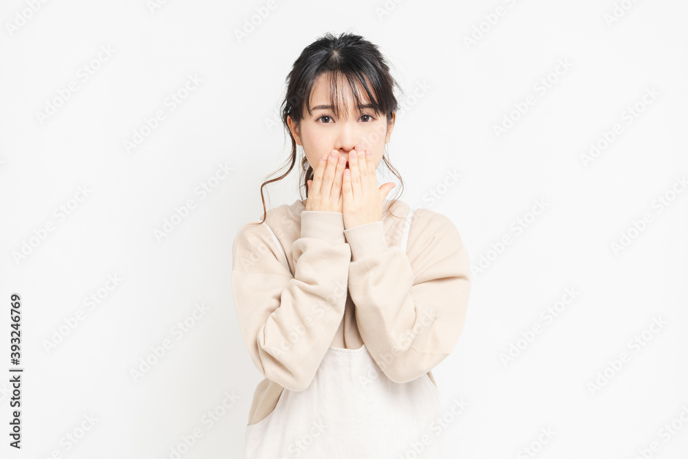 手で口を隠す若い女性 手で口を隠す若い女性