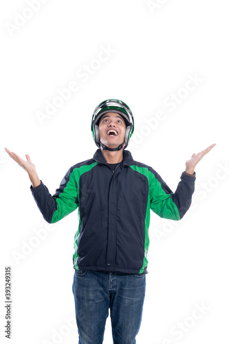 suprised male motorcycle rider with helmet looking up to copy space