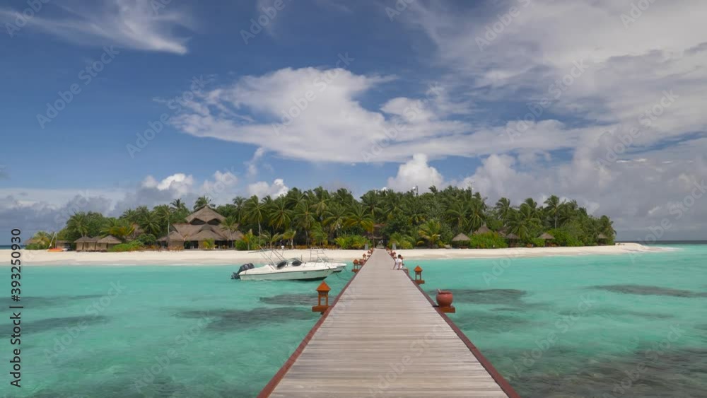 Man relaxes alone on jeti by tropical island with palm trees and beaches Man relaxes alone on jeti by tropical island with palm trees and beaches