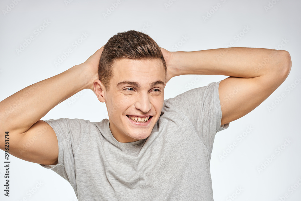 Cheerful emotional man gray t-shirt gesturing with hands studio lifestyle Cheerful emotional man gray t-shirt gesturing with hands studio lifestyle