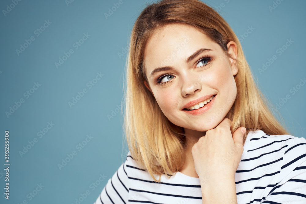 Blonde girl in striped t-shirt lifestyle blue background fun