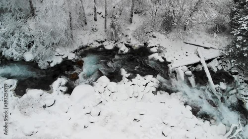 River in the winter snow forest in the mountains photo