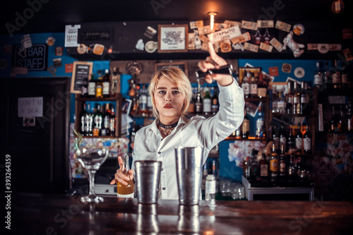 Professional woman bartending makes a show creating a cocktail in the bar