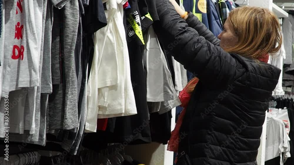 pretty elegant woman shopping in clothes store. pretty elegant woman shopping in clothes store.