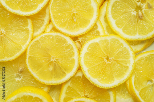 Fruit background, top view. Juicy yellow lemon cut into round slices.