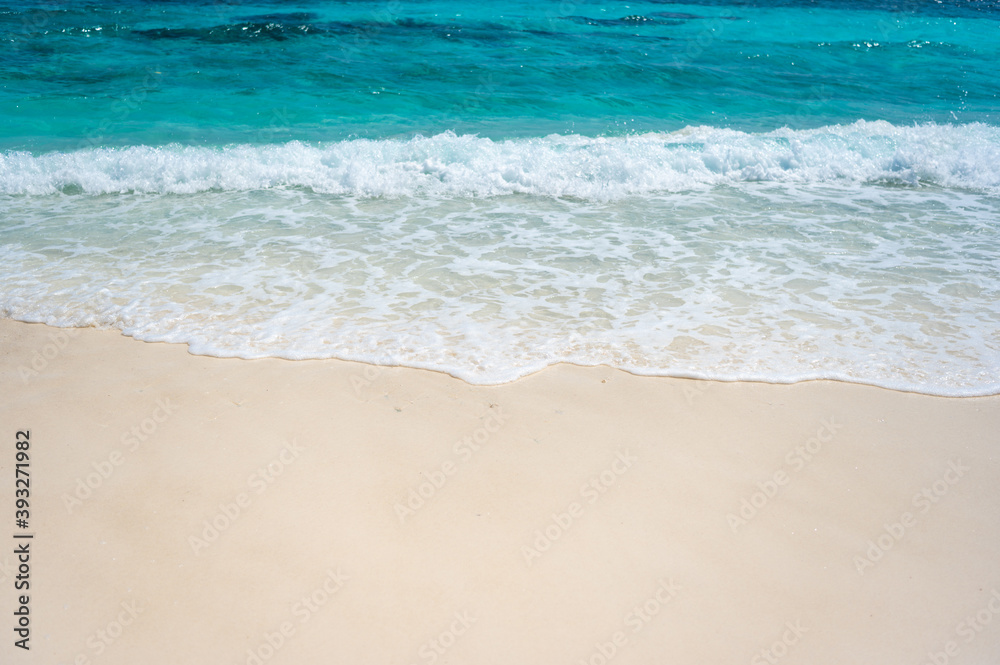 Clear sea waves and white sandy beach in summer.
