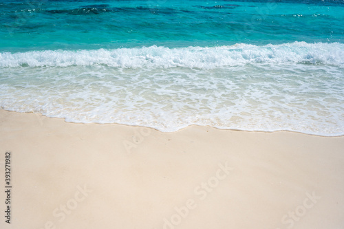 Clear sea waves and white sandy beach in summer.