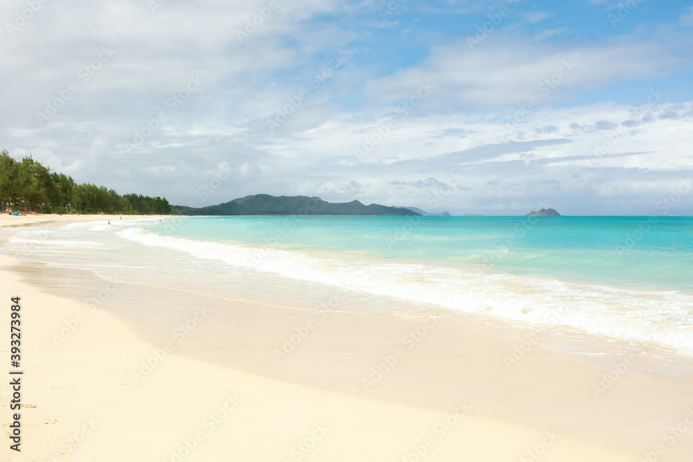 Empty Hawaiian beach with white sand and aqua blue water