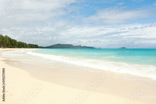 Empty Hawaiian beach with white sand and aqua blue water