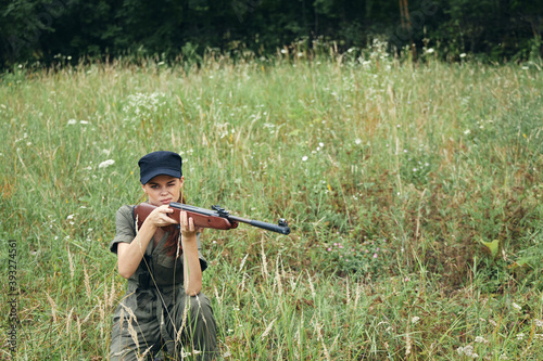 Woman A woman with a weapon in her hands on a squatting sight fresh air